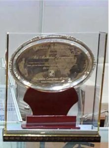 A silver trophy is on display in a glass case.